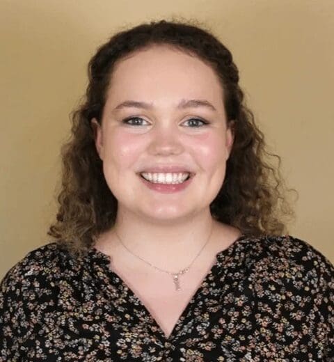 Smiling woman wearing necklace and floral blouse