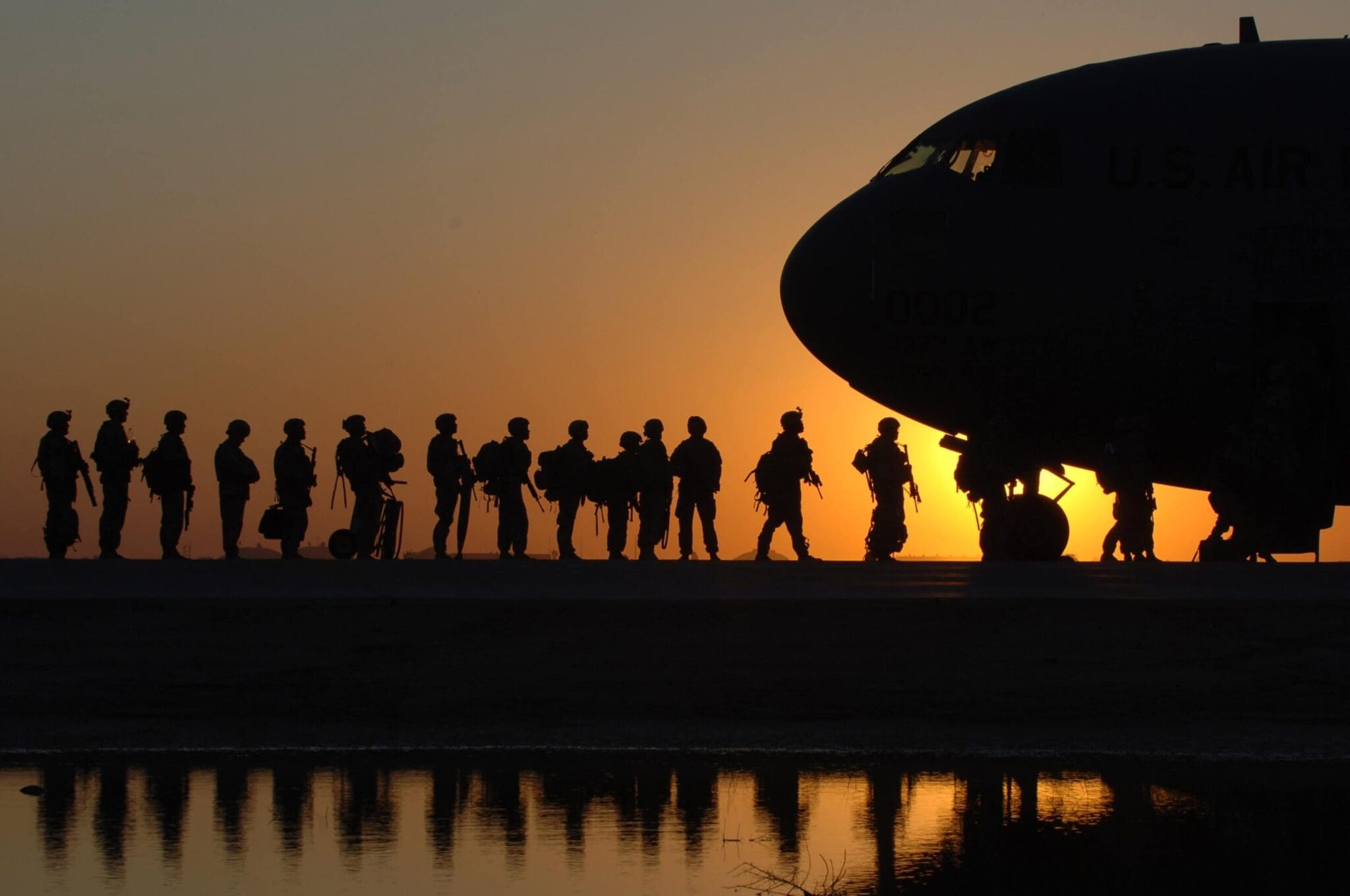 Soldiers boarding military transport at sunset