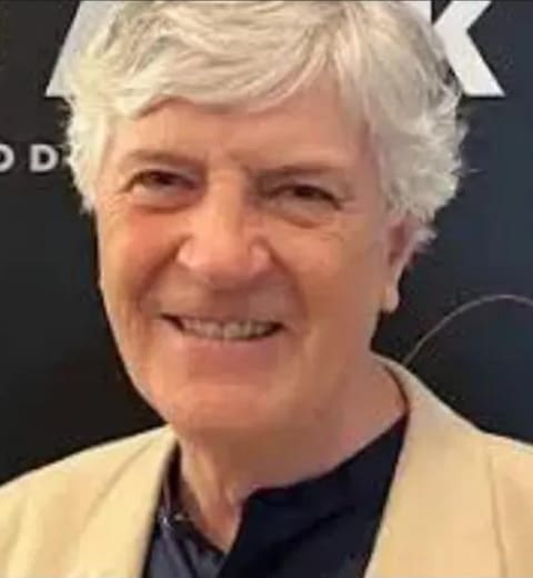 Smiling older man with gray hair.