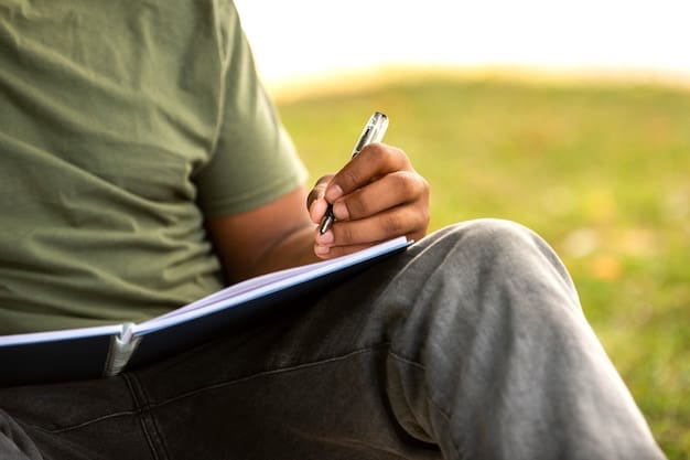 Person writing in a notebook outdoors.